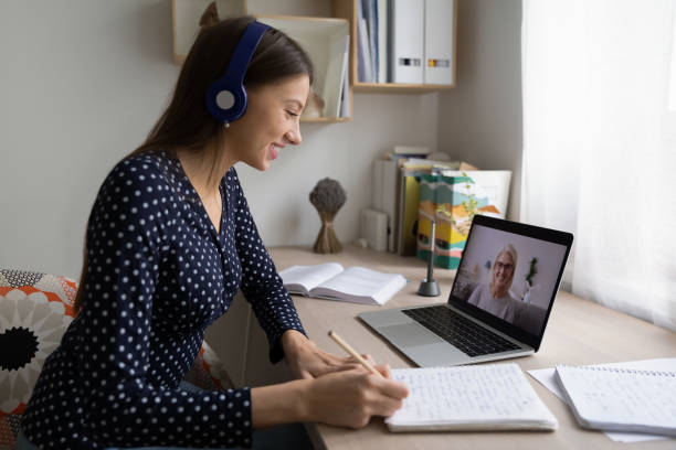 istock Smiling girl male notes study distant on laptop 1262378661