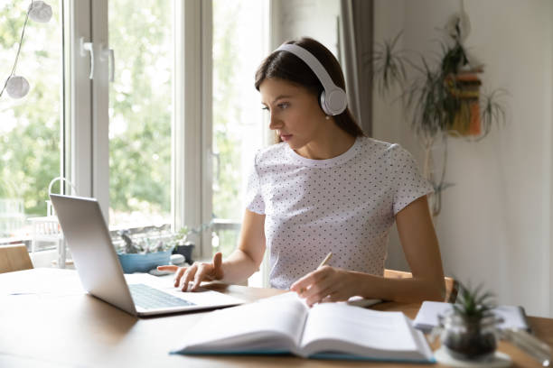 istock Female student in earphones study using laptop 1262378769