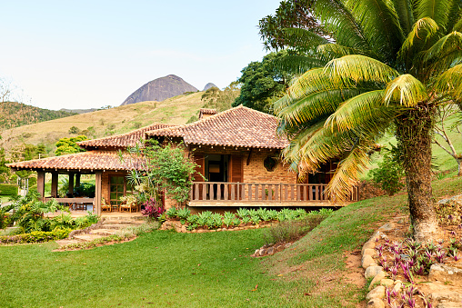 Front yard of a beautiful brick house with plants and green lawn