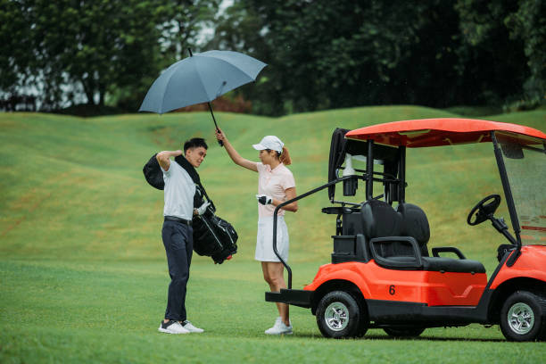 아시아 의 젊은 커플 골퍼 와 블루 우산 에 이 골프 코스 - golf cart golf bag horizontal outdoors 뉴스 사진 이미지