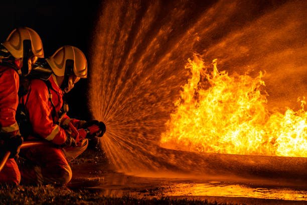 istock Firefighters use twirl water fog spraying down fire flame. 1262389020