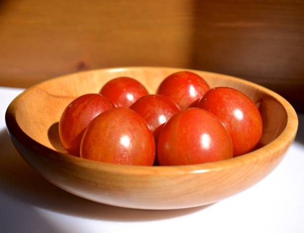 Cherry tomatoes in a wooden bowl stock photo