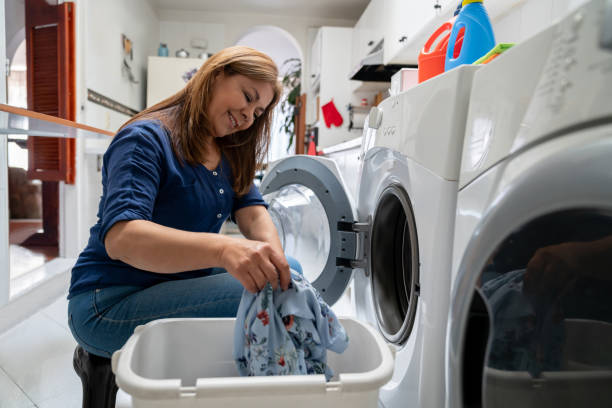istock Happy woman at home doing the laundry 1262396276