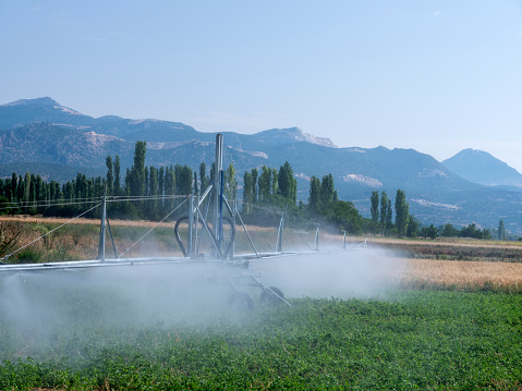 Irrigating a green field with a moving system.
