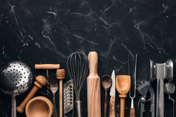 istock Various kitchen utensils and tools on a black stone background. Top view, flat lay, copy space. Collection kitchenware. 1262396472