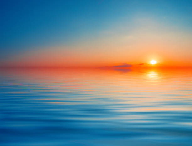istock Dramatic orange with blue sky over the water 1262396699
