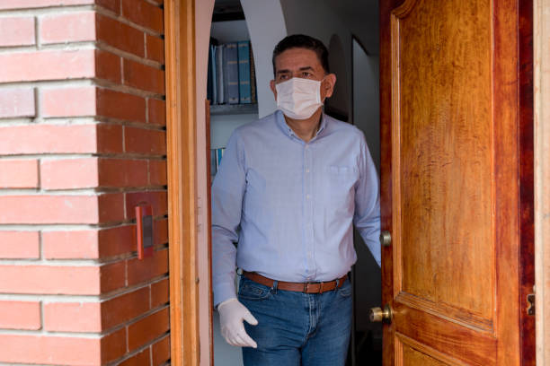 istock Man leaving his house wearing a facemask and gloves 1262401163