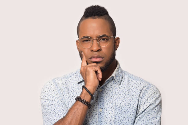 istock Pensive black male in glasses isolated on grey background thinking 1262402097