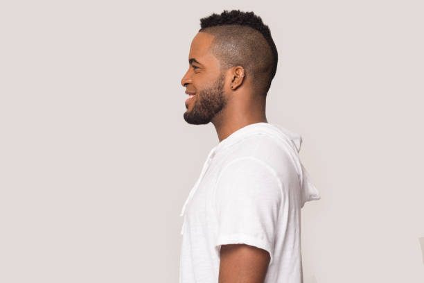 istock Smiling black man stand in profile isolated in studio 1262402132