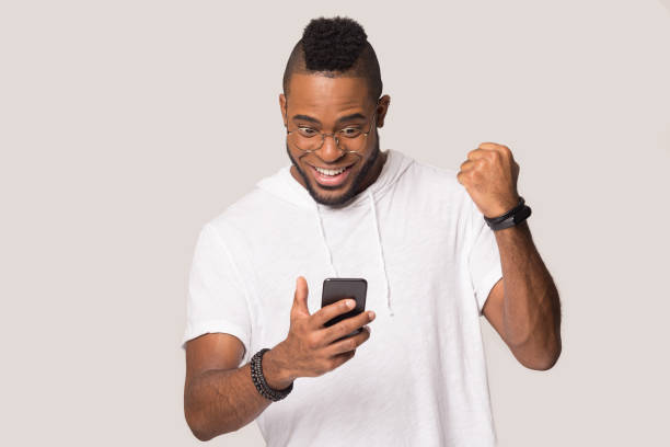 istock Happy african American man hold smartphone get good message 1262402143