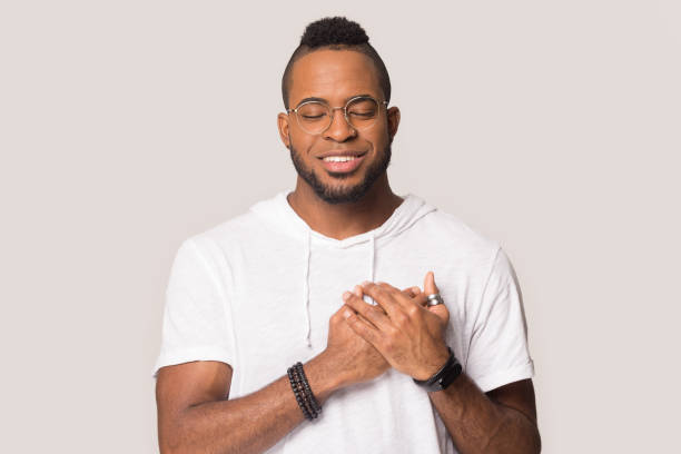 istock Grateful black man hold hands at chest feeling thankful 1262402149