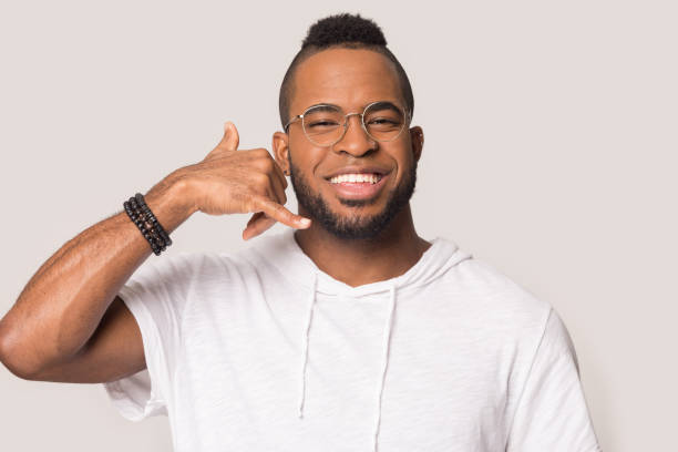 istock Smiling black man show call me gesture isolated in studio 1262402154