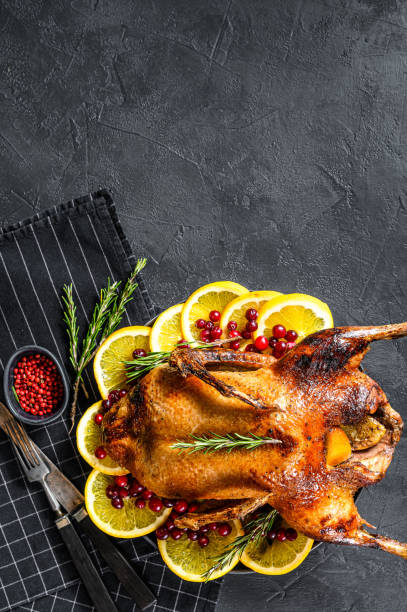 istock Baked duck stuffed with oranges and rosmarina. Festive table. Black background. Top view. Space for text 1262402256