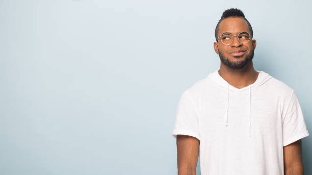istock Smiling black male look at copy space consider offer 1262402832