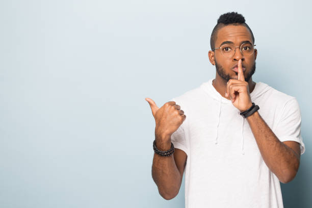 istock Black male make hush gesture point at copy space 1262402834