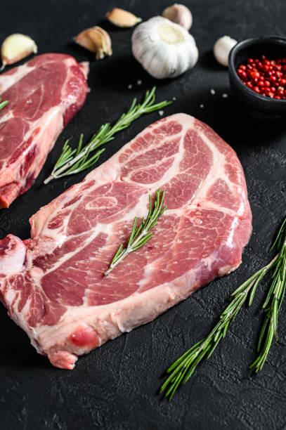 istock Fresh pork steak. Marbled meat. Black background. Top view 1262407493