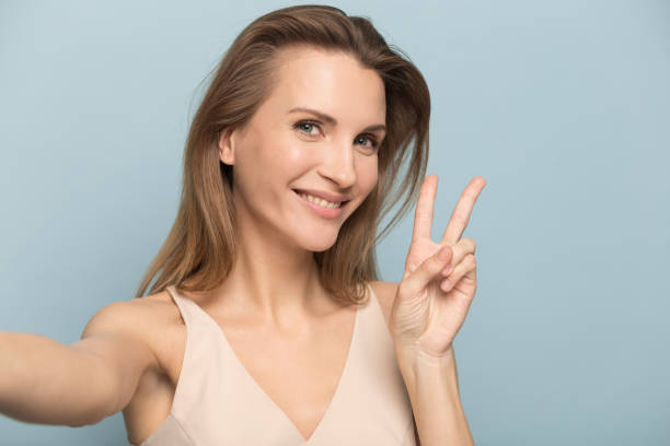 istock Smiling woman make self-portrait picture in studio 1262412398
