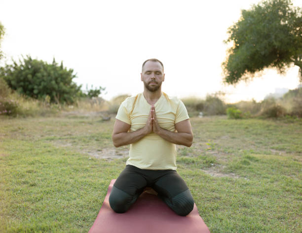 istock Handsome young man practising yoga at outside garden 1262412573