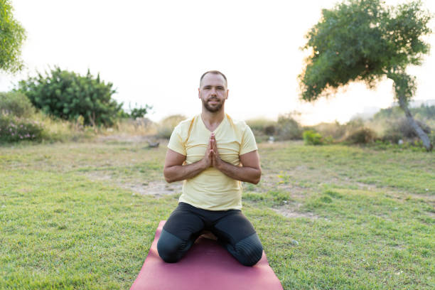 istock Handsome young man practising yoga at outside garden 1262412825