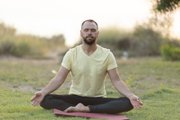 istock Handsome young man practising yoga at outside garden 1262413659