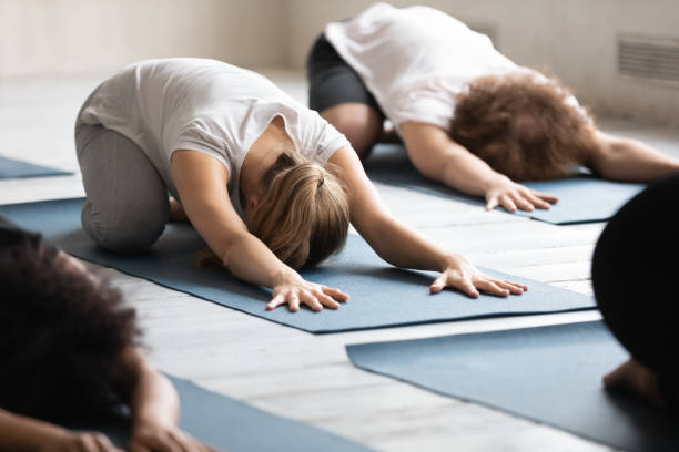 istock Young female beginner lying on floor mat in balasana pose. 1262414047