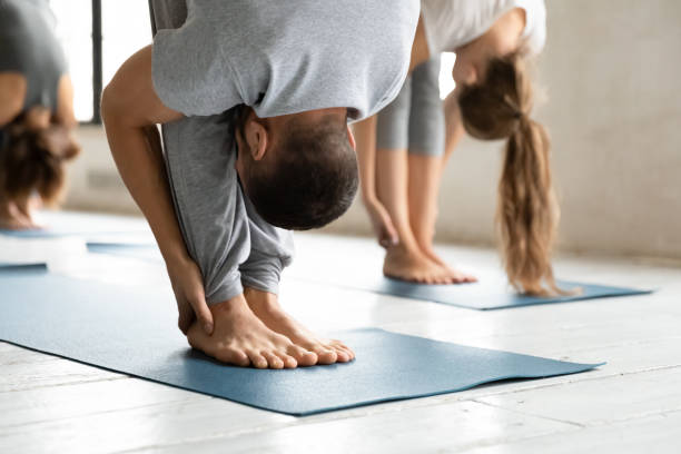 istock Young male master standing in forward bend head to legs position. 1262414054