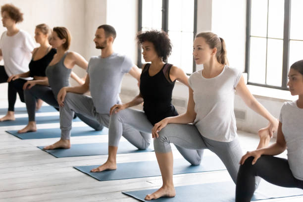 Young strong mixed race people practicing Eka Pada Rajakapotasana.
