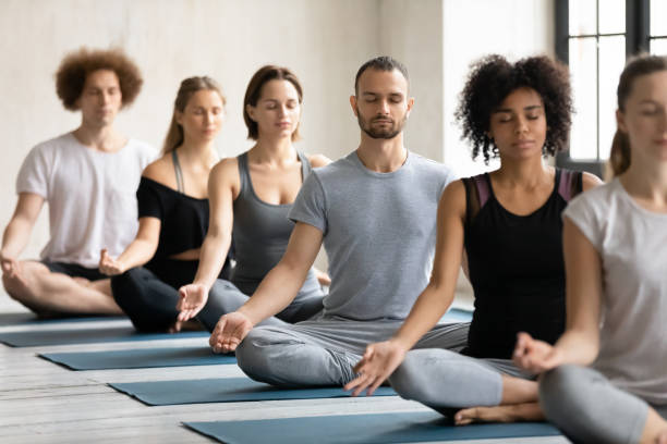 istock Young fit multiracial people meditating in padmasana. 1262414096