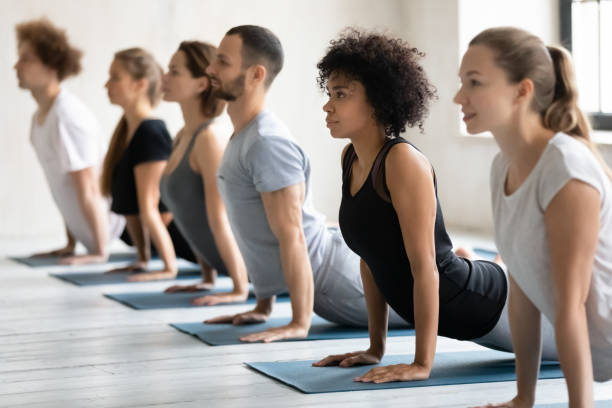 Young healthy mixed race sporty people practicing Cobra pose.