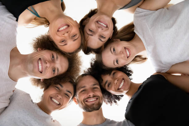 istock Smiling beautiful mixed race people touching heads in circle. 1262414142