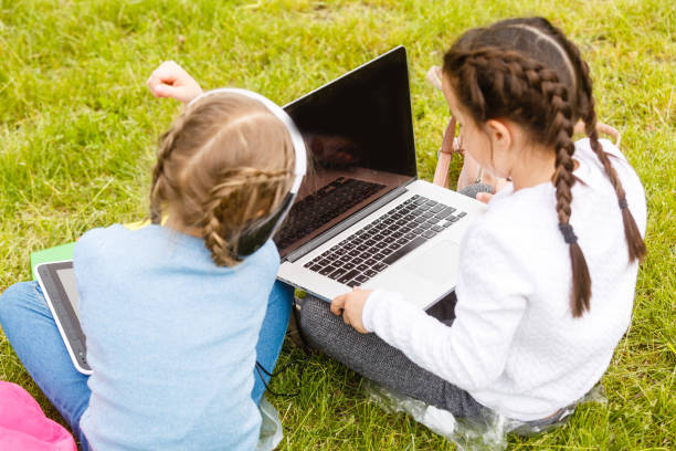 istock Two beautiful sisters do their homework during quarantine. Children use gadgets for learning. Education, distance learning, home schooling during quarantine 1262417609