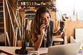 tischlerin-mit-einem-laptop-in-ihrer-werkstatt-sprechen-auf-einem-smartphone.jpg?b=1&s=170x170&k=20&c=572LUh8H-FcXwKLcOA1cEnw1H-K1fwBrp_OfTkZSo3Q=