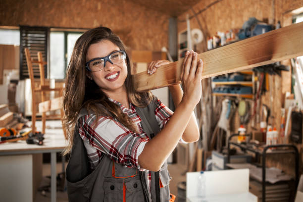 istock Female Carpenter carrying Wooden Plank 1262418547
