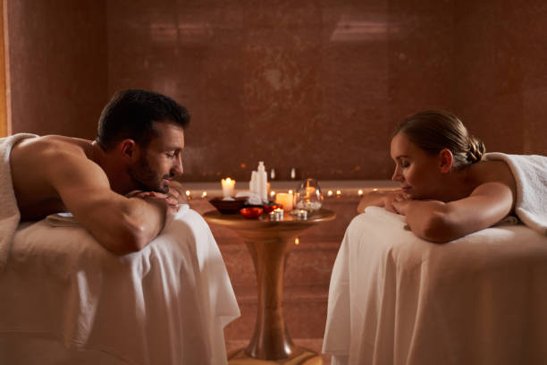 atmosfera romantica nel salone di bellezza dopo un piacevole massaggio - spa treatment health spa massaging couple foto e immagini stock