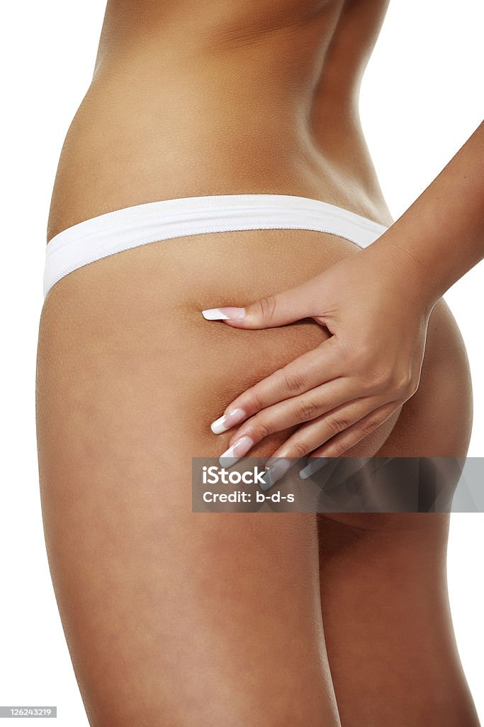 No cellulite Woman squeezing her buttock and showing no cellulite in her perfectly shaped body. Isolated on white. Adult Stock Photo