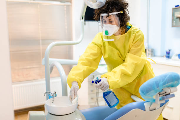 istock Dentist assistant using strong disinfectant agent to clean dental office for the next patient 1262435078