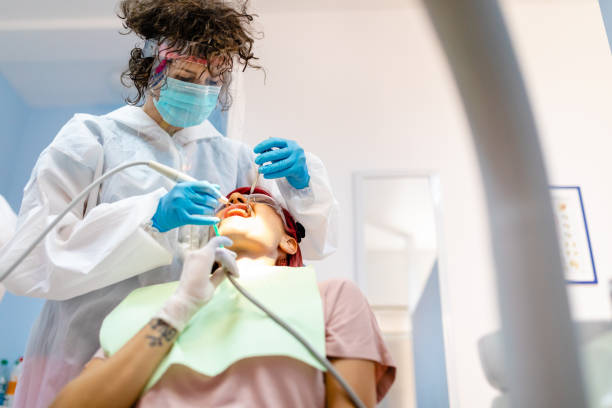 여성 치주환자는 환자가 아름다운 미소를 가질 수 있도록 에나멜에서 단단하고 부드러운 예금을 제거합니다. - dental equipment dental drill dentist surgical mask 뉴스 사진 이미지