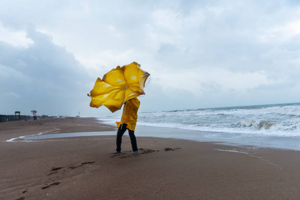 uomo su spiaggia tempestosa - rain tornado overcast storm foto e immagini stock