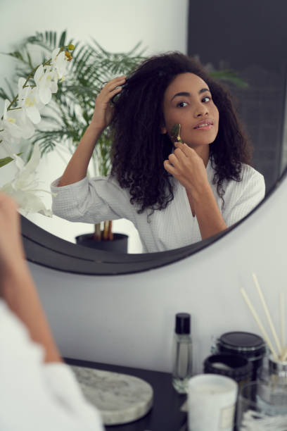 istock Beautiful young woman doing face massage at home 1262451291