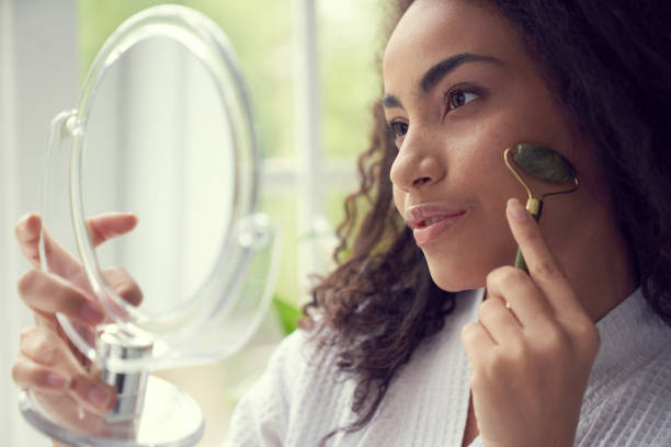 istock Young woman using jade roller at home 1262451301