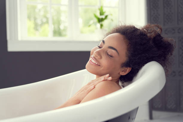 istock Happy young lady enjoying time alone in bathroom 1262451370