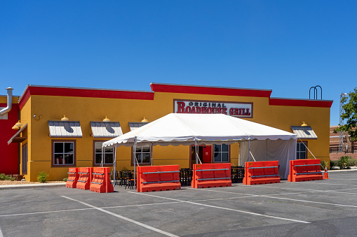 Victorville, CA / USA – July 29, 2020: Due to COVID-19 and Social Distancing, Original Roadhouse Grill restaurant in Victorville, California, offers temporary outdoor seating under a tent.