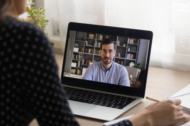 Back view of female talk on video call with coach Close up back view of girl look at laptop screen talk on video call with male teacher or trainer, woman student have online distant webcam conversation or virtual conference with man coach or tutor online tutors stock pictures, royalty-free photos & images