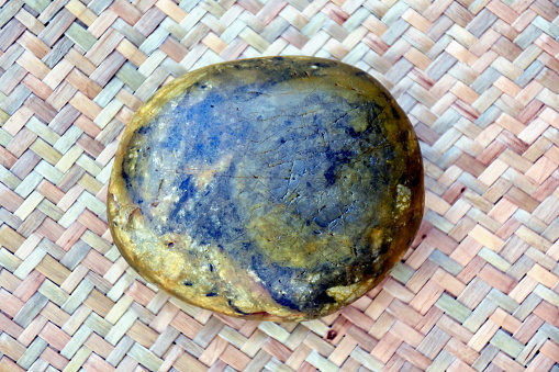 Overhead view of a whole parmesan cheese wheel with aged crust, isolated on a white background