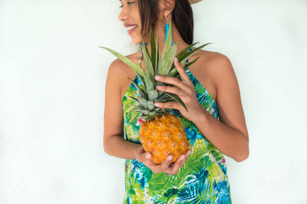 istock Woman holding a pineapple against a white wall 1262478723
