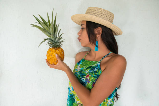 istock Woman holding a pineapple against a white wall 1262478728