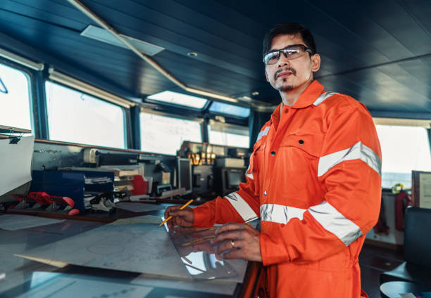 istock Filipino deck Officer on bridge of vessel or ship. He is plotting position on chart 1262480238