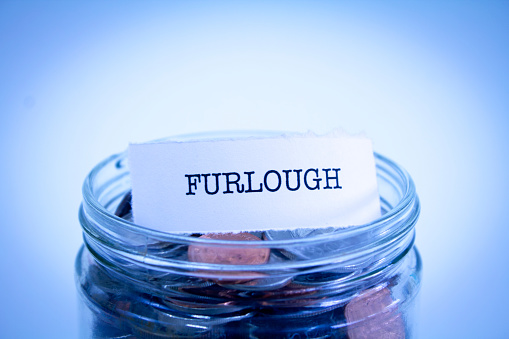 A close-up shot of the word Furlough on a jar of coins.
