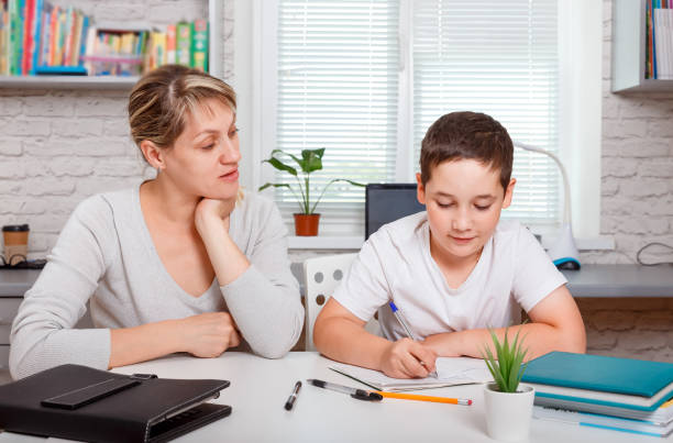 istock A schoolboy boy studies at home and does school homework online 1262494679