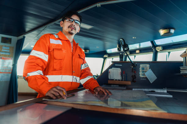 istock Filipino deck Officer on bridge of vessel or ship. He is plotting position on chart 1262495518